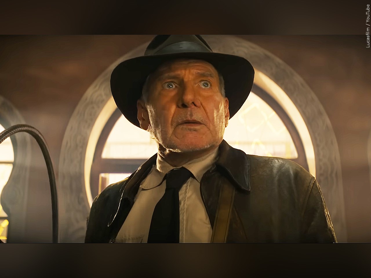 Indiana Jones looking caught off guard in front a window, wearing his trademark hat (Photo: Lucasfilm / YouTube)