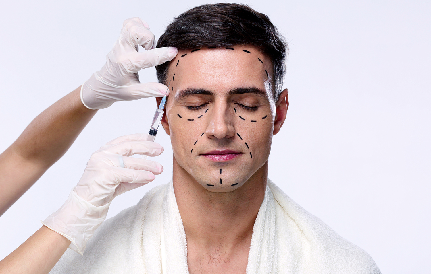Man with closed eyes at plastic surgery with syringe in his face